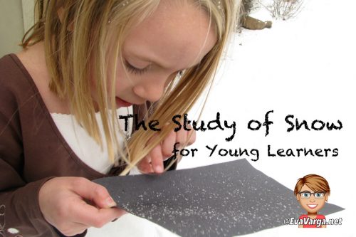 young girl examines freshly fallen snow on black paper